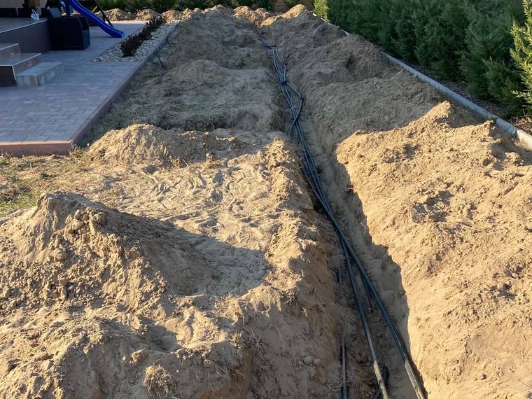 Kiásott árokban fektetett öntözőcsövek és szerelvények a telepítés során